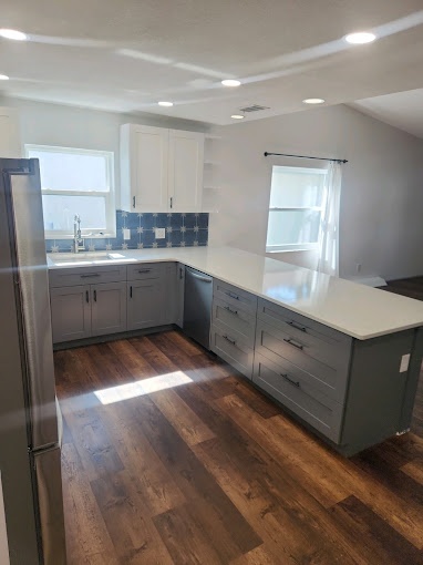 A kitchen with a refrigerator and a sink