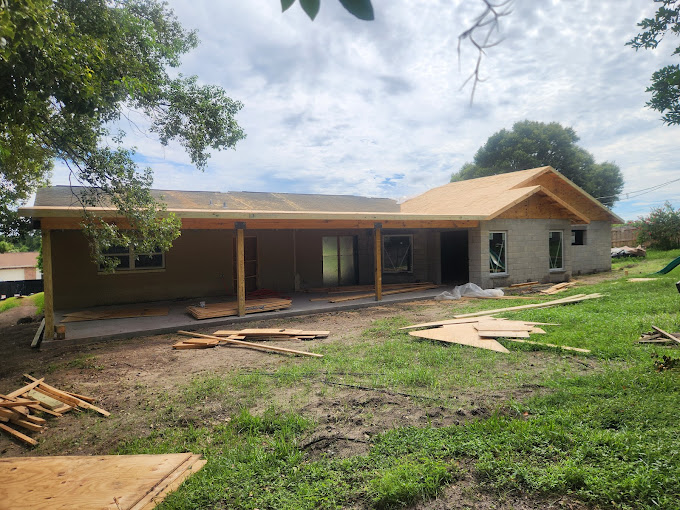 A house under construction in the middle of a field