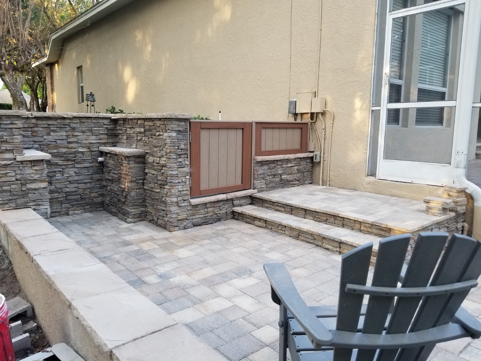 A patio with a stone wall and steps