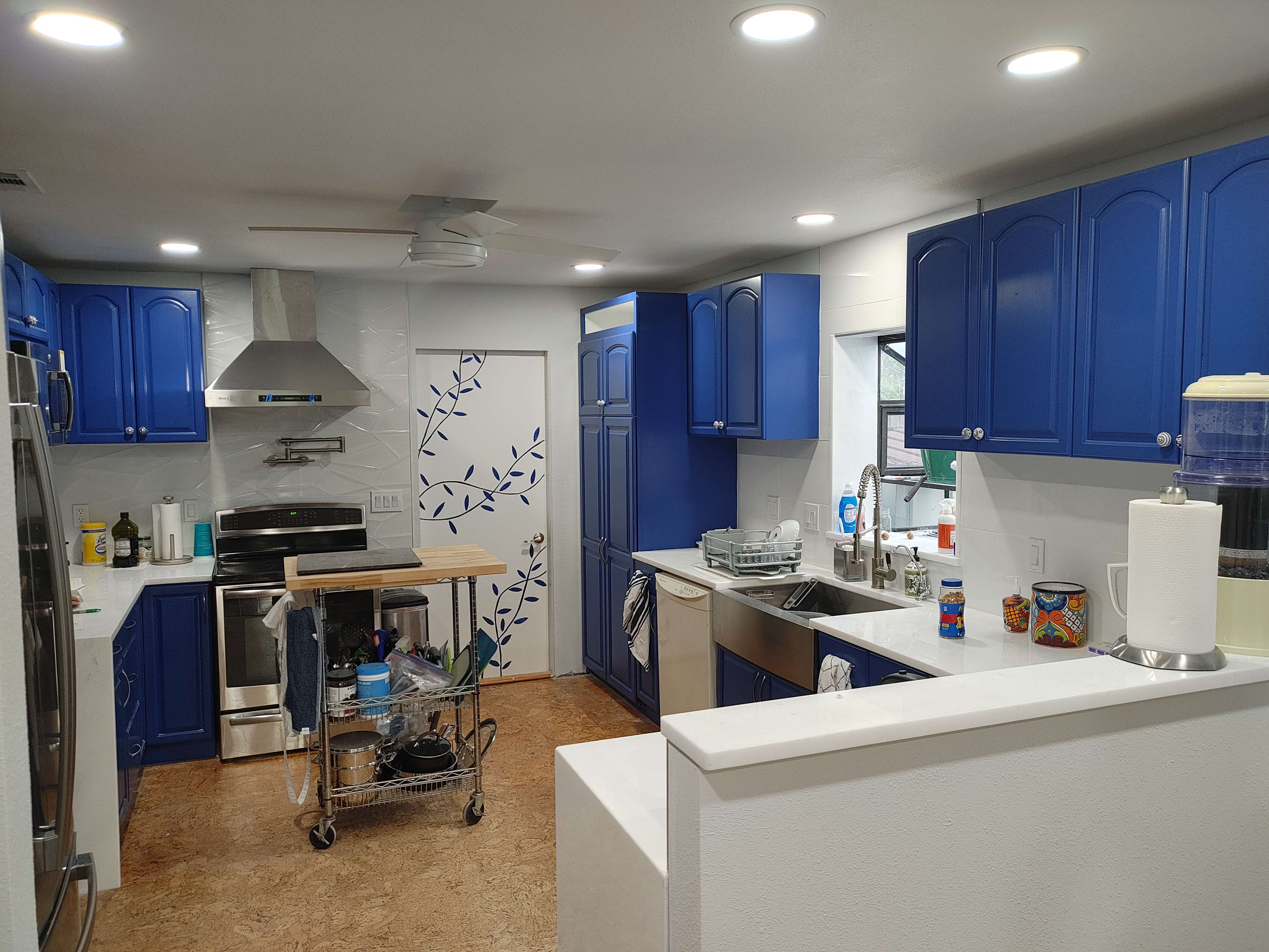 A kitchen with blue cabinets and stainless steel appliances