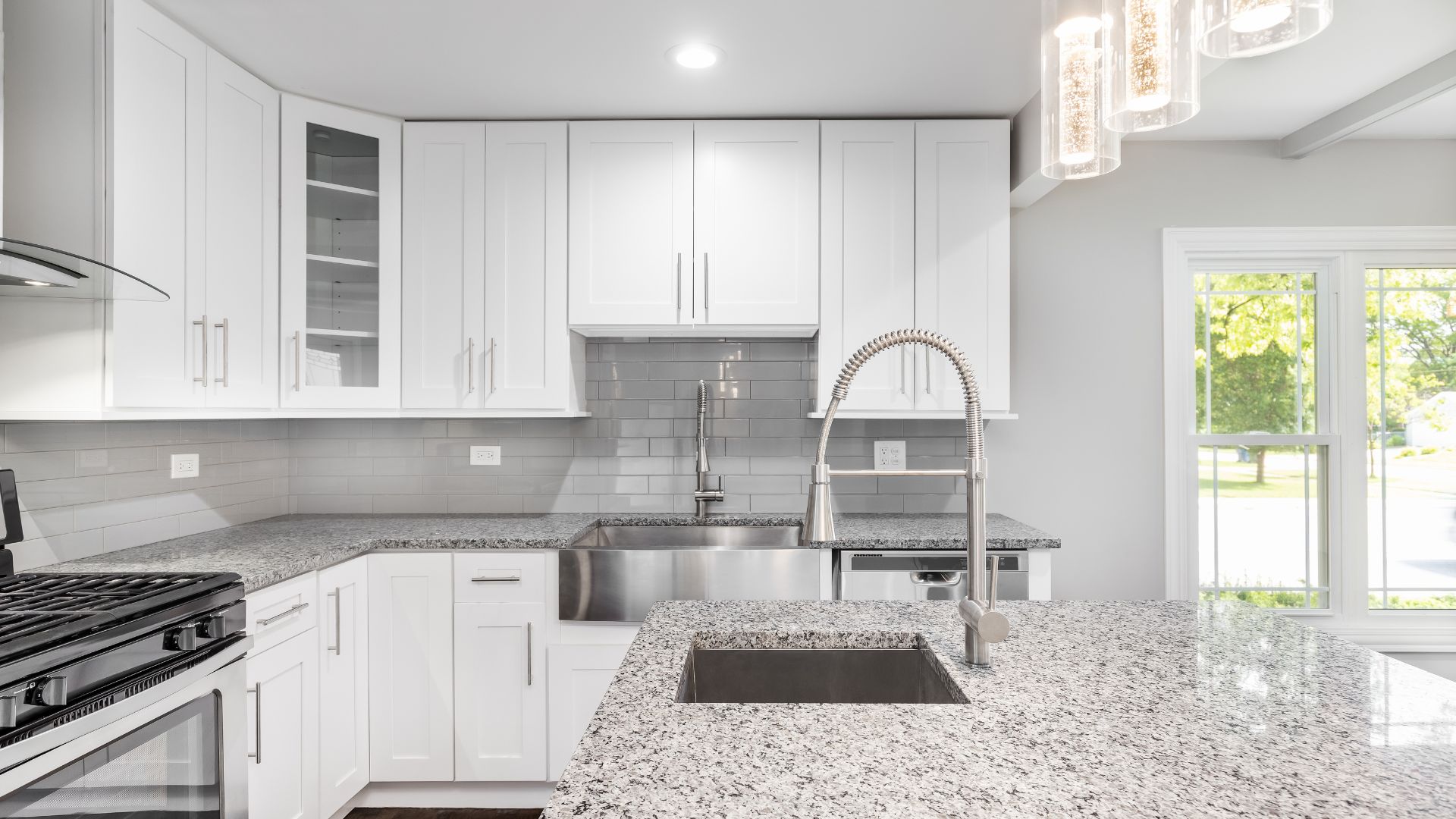 A kitchen with white cabinets and granite counter tops